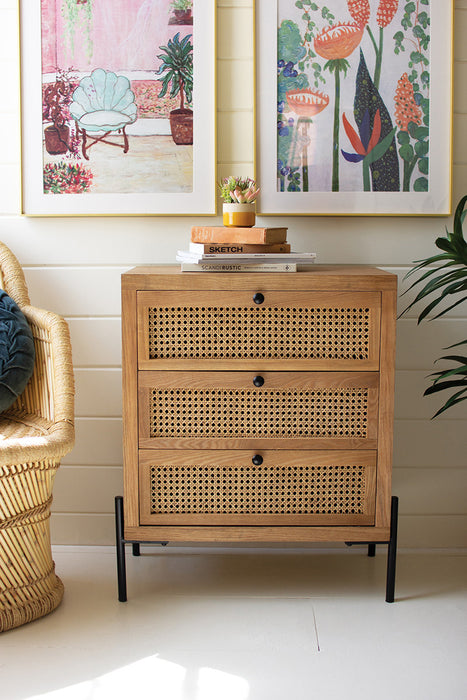 wooden bedside table with three woven cane drawers